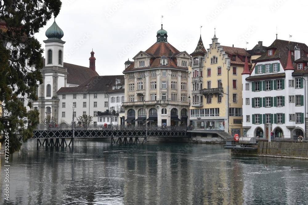 Jesuit church and other historic buildings on the bank of river Reuss in Luzern. View from the opposite riverbank. 