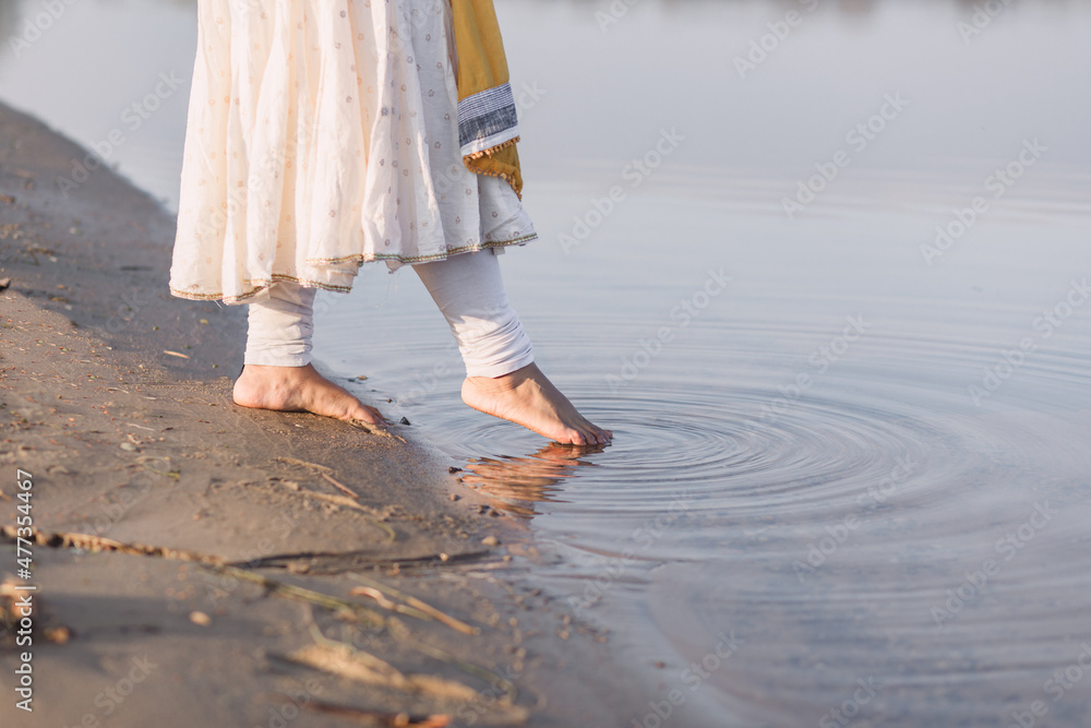 Woman dipping toes in lake