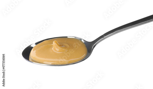 Spoon of delicious peanut butter on white background
