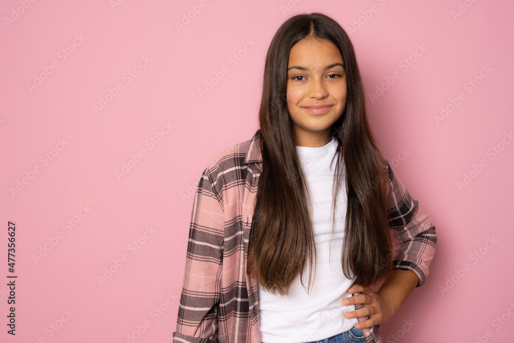 Fototapeta premium Close up portrait of a beautiful brunette girl in casual plaid shirt isolated over pink background.