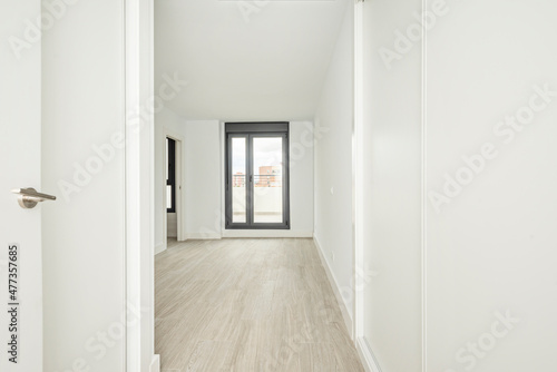 Entrance door to empty room with freshly painted walls with wardrobe with small sliding doors