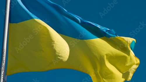 State Flag of Ukraine. The Big State Flag is illuminated by the sun and flutters epically in the wind against the blue sky. Slow Motion 120 fps photo