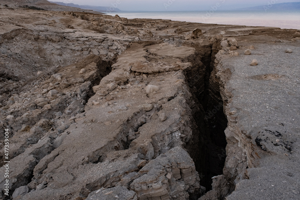 View of Dead Sea sinkholes (or swallows), a deep hole in the ground formed abruptly along the coastline of the Dead Sea, Ein Gedi, Israel.
