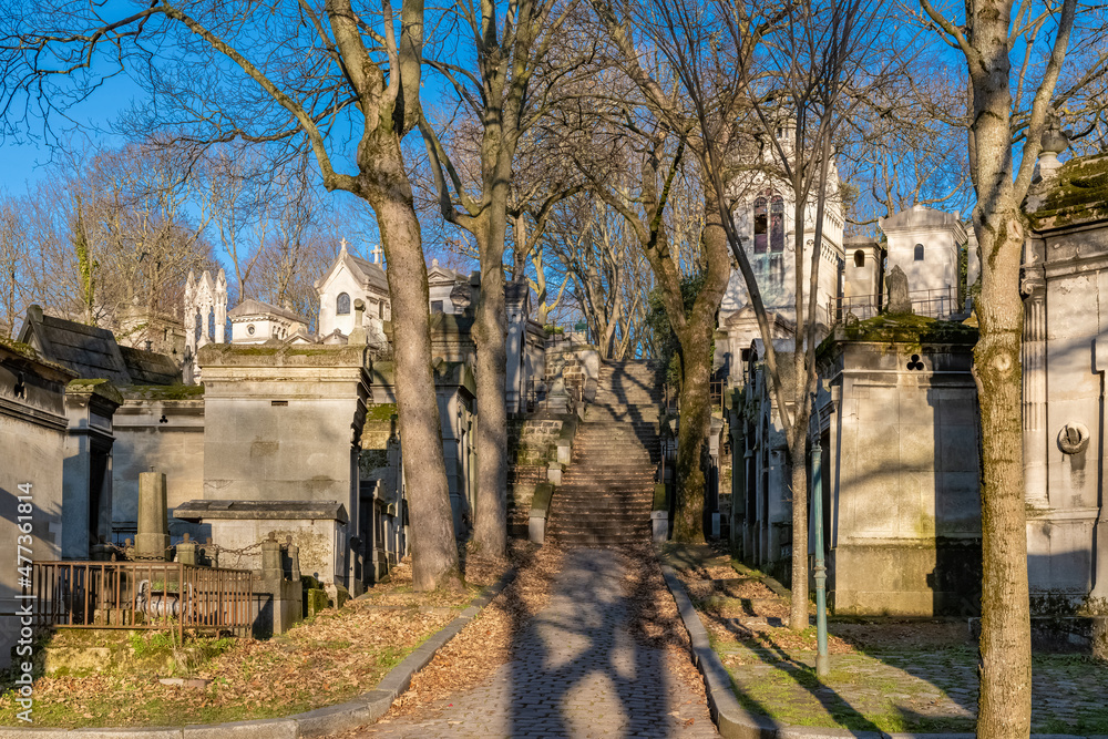 Paris, the Pere-Lachaise cemetery, cobbled alley with graves in winter
