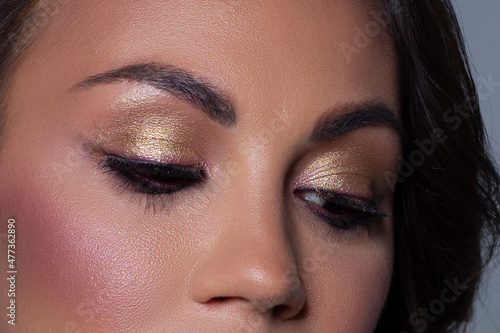 Elegance close-up female eye with light pink eyeshadow. Macro shot of part of the face of a beautiful woman. Wellness, cosmetics and makeup. smooth beautiful eyebrows and eyelashes © evgeniyasht19