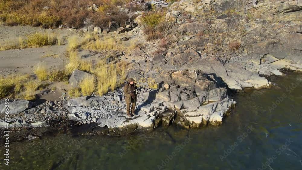 river autumn fisherman fishing at the edge of a cliff fishing rod from a copter river autumn fisherman fishing at the edge of a cliff fishing rod from a copter