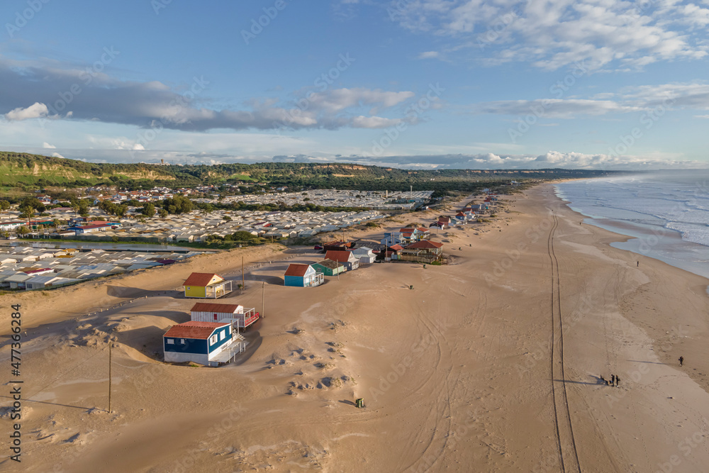 Aerial view of small wooden houses along the beach in Caparica, Setubal, Portugal. Aerial view of small wooden houses along the beach in Caparica, Setubal, Portugal.