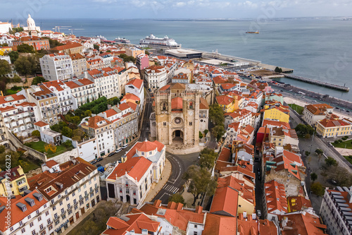 Aerial view of Lisbon cathedral in Alfama district with Tagus river in background, Lisbon, Portugal.