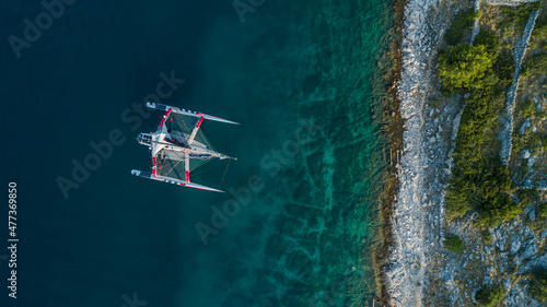 Aerial view of a catamaran along the coastline near Otok Zut, a beautiful island along Croatian coast, Croatia. photo