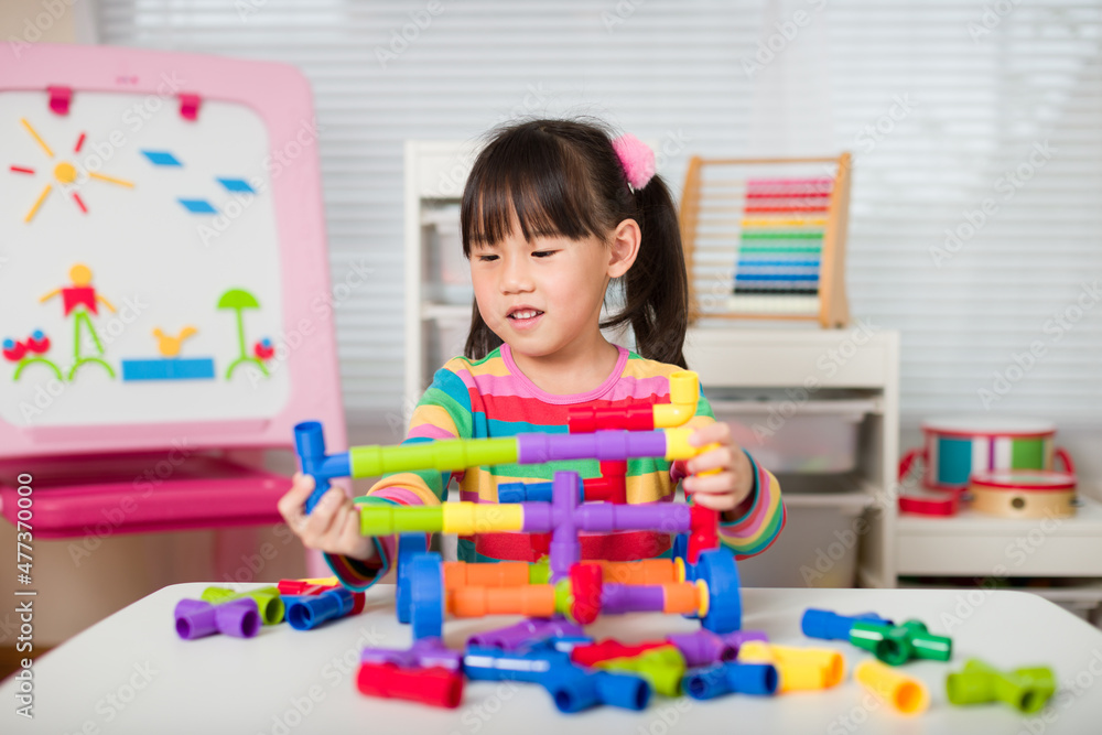 young girl playing water pipe construsction toy at home young girl playing water pipe construsction toy at home