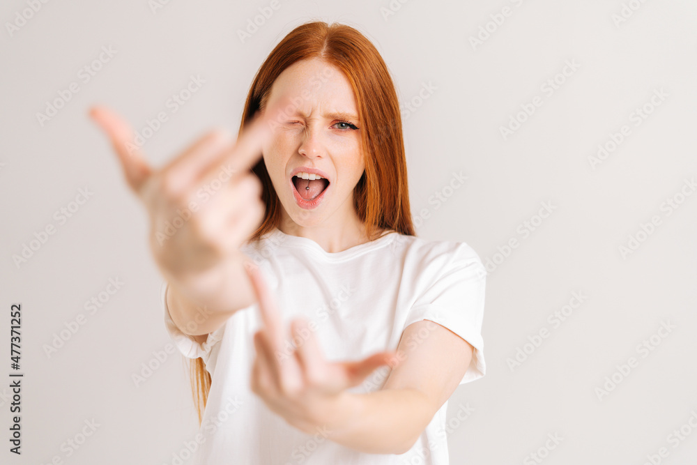 Close-up portrait of excited crazy young woman showing middle fingers on both arms, gesture of disrespect and hate, doing bad expression. Rude and rude female showing middle finger looking at camera. Close-up portrait of excited crazy young woman showing middle fingers on both arms, gesture of disrespect and hate, doing bad expression. Rude and rude female showing middle finger looking at camera.
