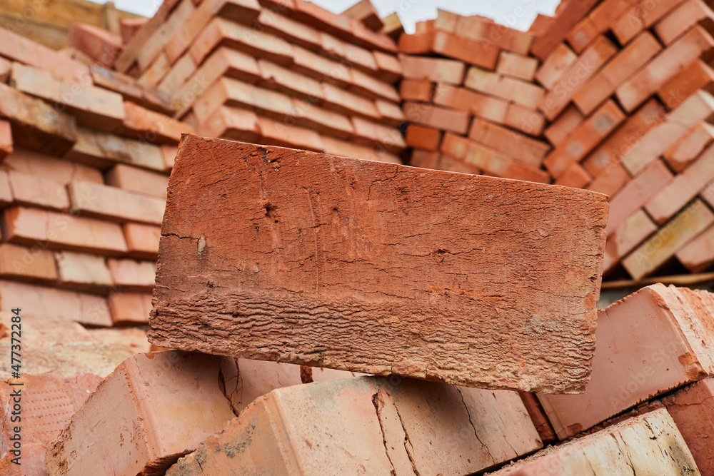 A stack of red clay bricks in rows close up. Lot of stacks of bricks on construction site Stock