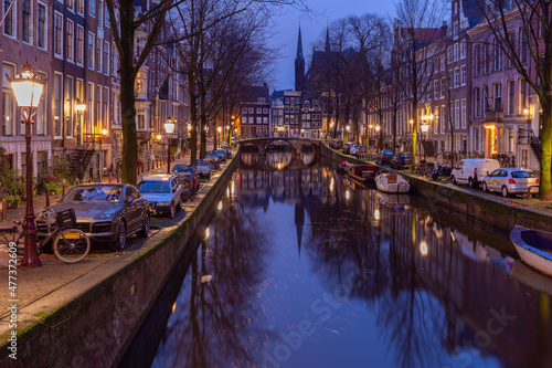 Beautiful old houses on the city waterfront of Amsterdam at sunset.