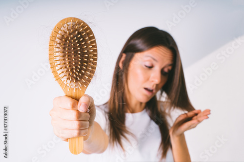 Woman with hair brush with damaged hair. Hair loss problem. Bad hair falling out