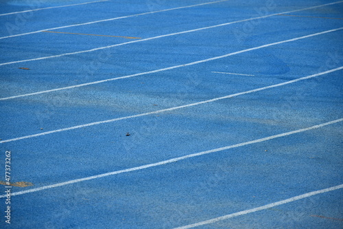 Curved running track on a blue field © Siripat