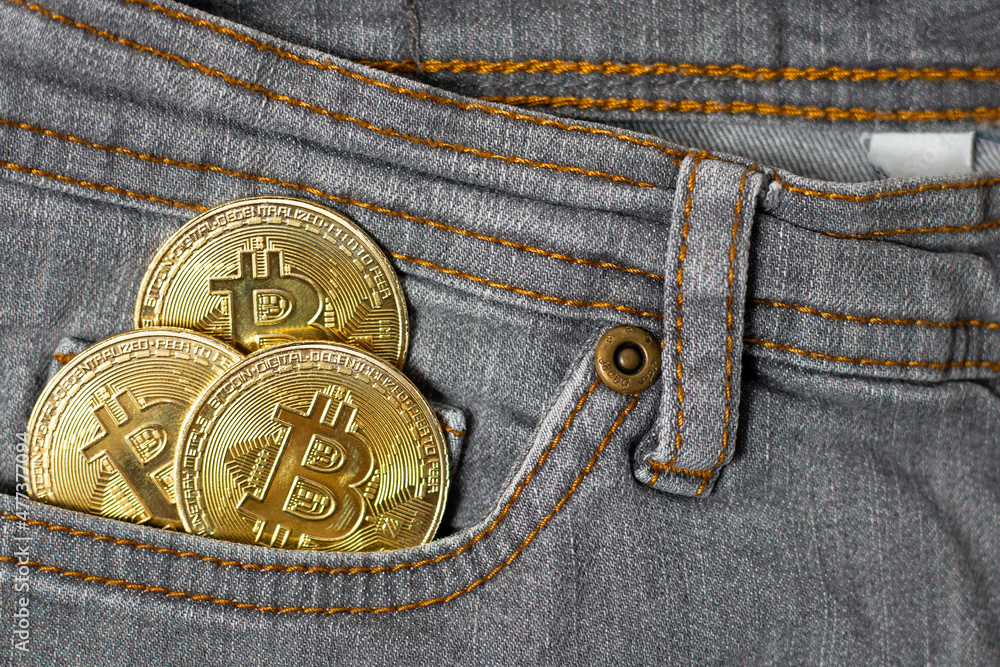 3 gold bitcoins in the pocket of gray women's pants. 3 gold bitcoins in the pocket of gray women's pants.
