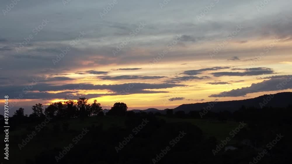 Sunset in farming landscape at countryside rural scenery. Green forest trees between mountains. Sunset in farming landscape at countryside rural scenery. Green forest trees between mountains.