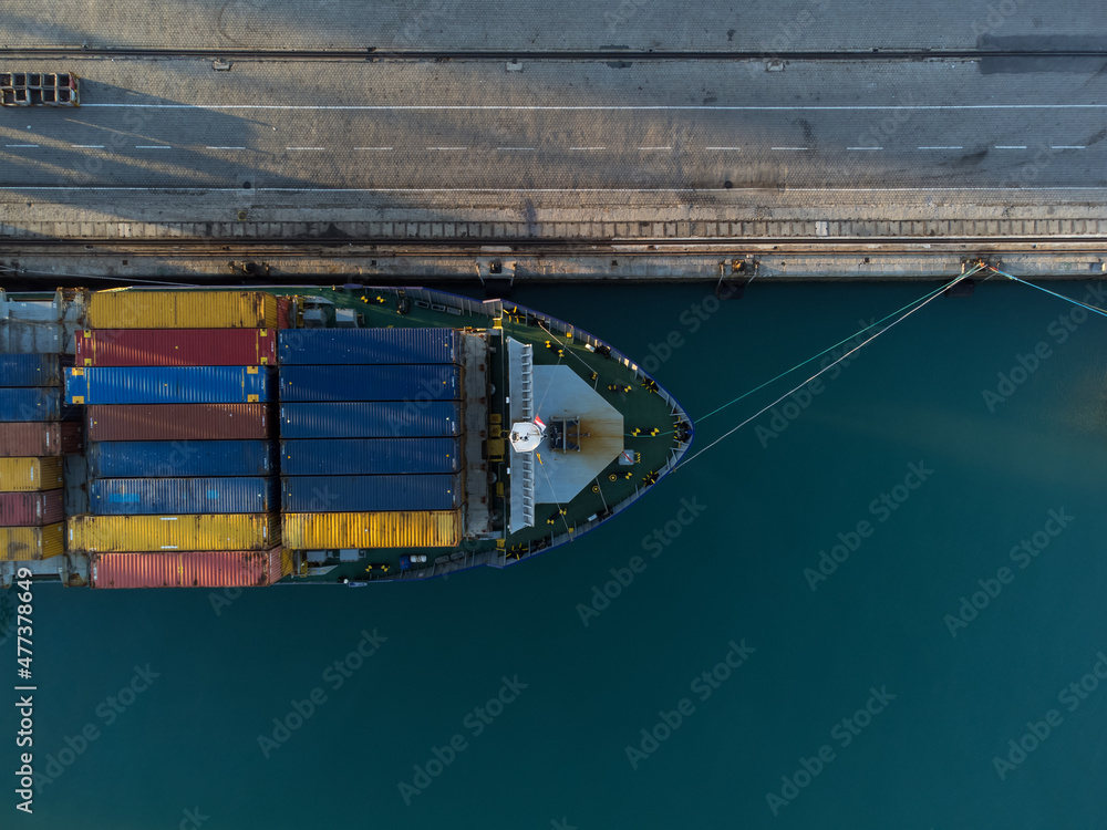 Cargo ship in port loading colorful containers. Maritime transport of merchandise in containers Aerial view of a ship