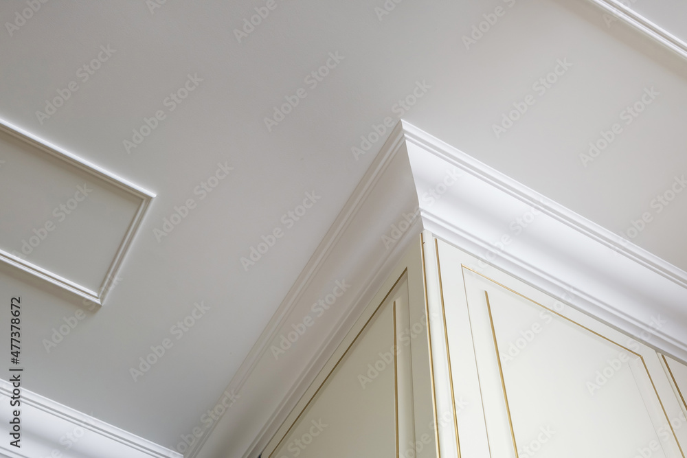 Detail of corner ceiling cornice with intricate crown molding. Stock Photo  | Adobe Stock