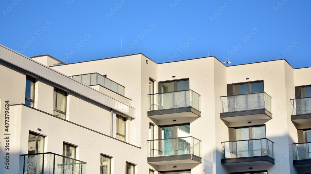  Facade of a modern apartment condominium in a sunny day. Modern condo buildings with huge windows and balconies.