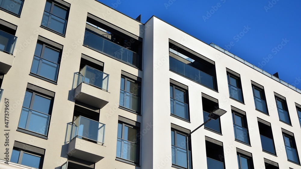Facade of a modern apartment condominium in a sunny day. Modern condo buildings with huge windows and balconies.