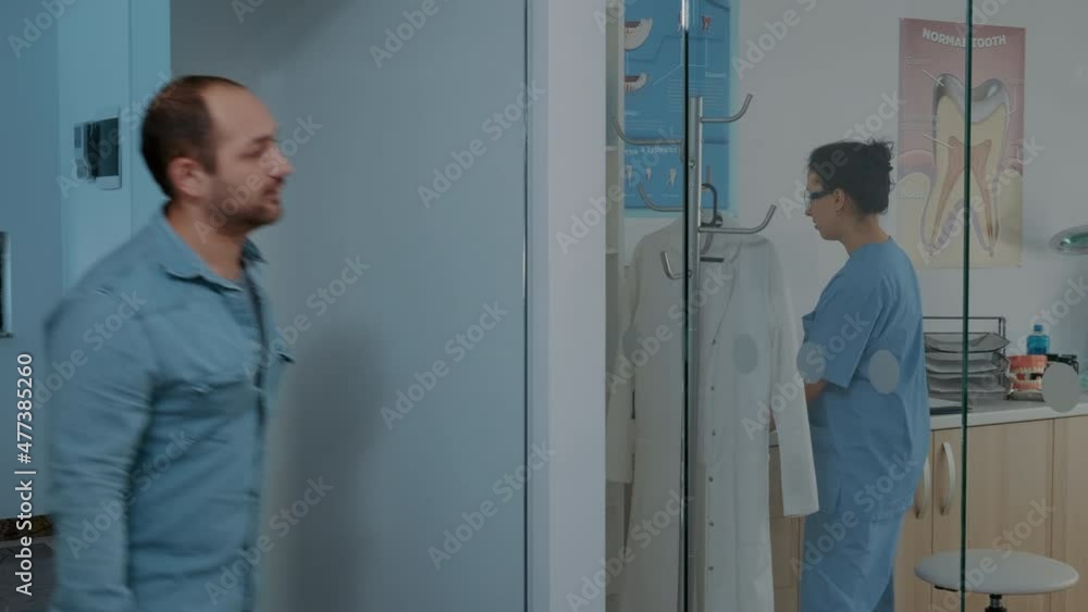 Patient with dental appointment arriving at stomatology cabinet, talking to mature dentist about oral care procedure. Man attending stomatological examination with specialist in cabinet. Patient with dental appointment arriving at stomatology cabinet, talking to mature dentist about oral care procedure. Man attending stomatological examination with specialist in cabinet.