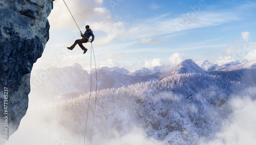 Cuadro en lienzo Adult adventurous man rappelling down a rocky cliff