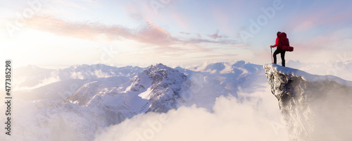 Fotografie, Tablou Adult adventurous woman standing on top of a snow peak