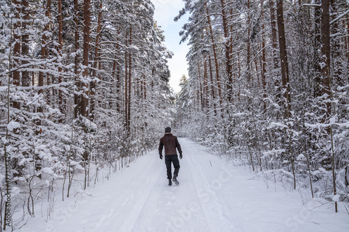 A young man is walking in snowy forest