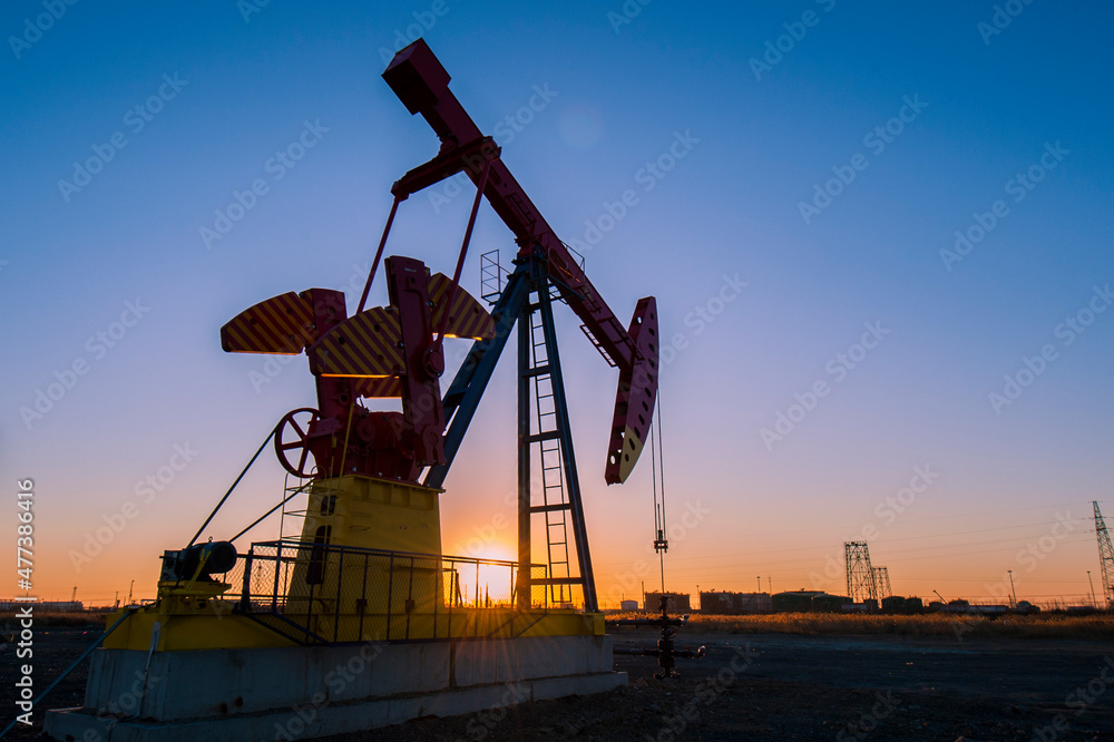 Oil pumps are running in the sunset at the oil field. On the Bohai coast of China.