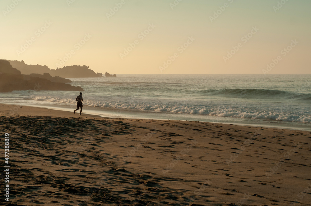 Hombre adulto blanco corriendo al amanecer en Playa Mermejita, Mazunte, Oaxaca. 