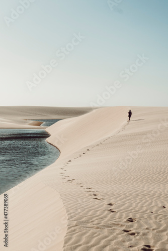 Lençóis Maranhenses - Lonely guy walking away leaving footsteps on the dunes of this brazilian national park
