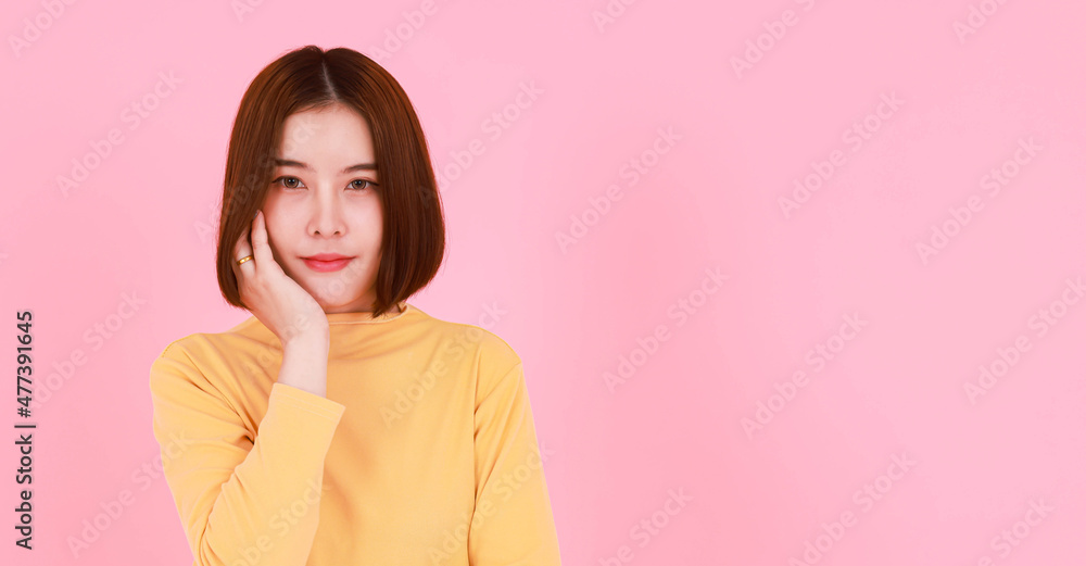 Portrait studio cutout shot of Asian young pretty short hair female model in yellow long sleeve shirt stand smile look at the camera on pink background. Portrait studio cutout shot of Asian young pretty short hair female model in yellow long sleeve shirt stand smile look at the camera on pink background.