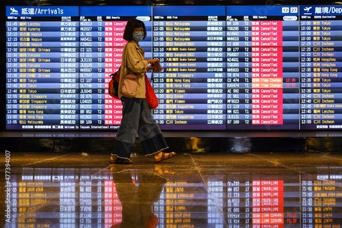 Wallpaper Mural East Asian woman with facemask walking in an airport Torontodigital.ca