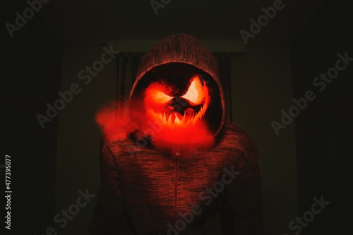 Person in hoodie with jack o lantern mask