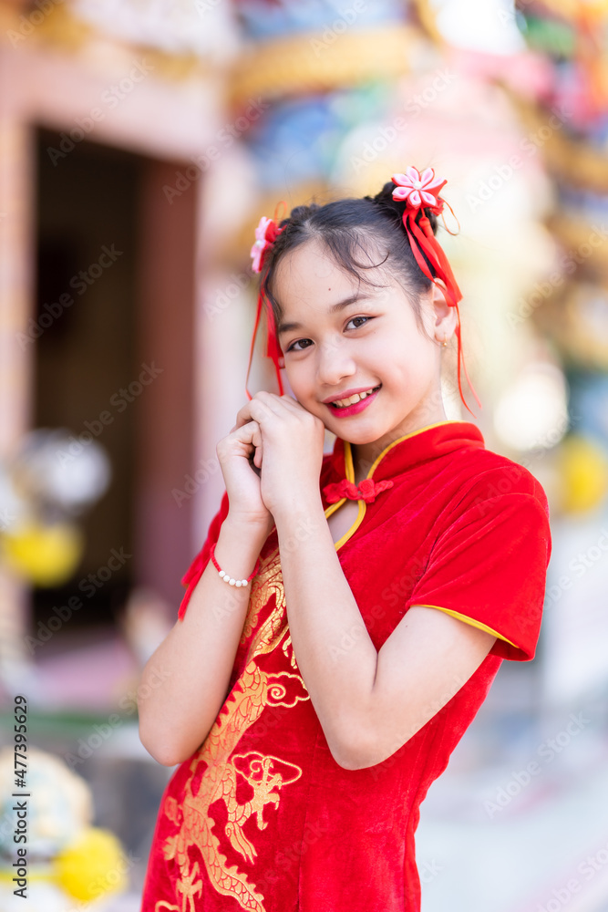 Portrait smiles Cute little Asian girl wearing red cheongsam dress traditional decoration for Chinese new year festival celebrate culture of china at Chinese shrine Portrait smiles Cute little Asian girl wearing red cheongsam dress traditional decoration for Chinese new year festival celebrate culture of china at Chinese shrine