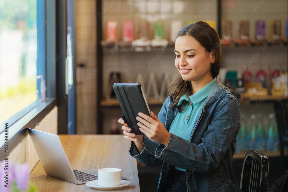 hipster sitting at window counter in coffee shop holding tablet hipster sitting at window counter in coffee shop holding tablet