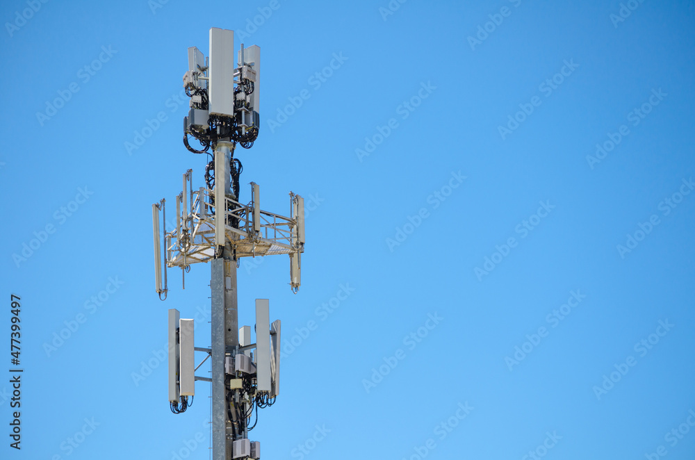Close up Cellular radio antenna with cable for the telecommunications tower isolated on blue sky background. Close up Cellular radio antenna with cable for the telecommunications tower isolated on blue sky background.