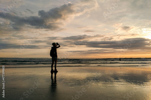 A woman enjoy the sunset at Seminyak beach in Bali Indonesia.