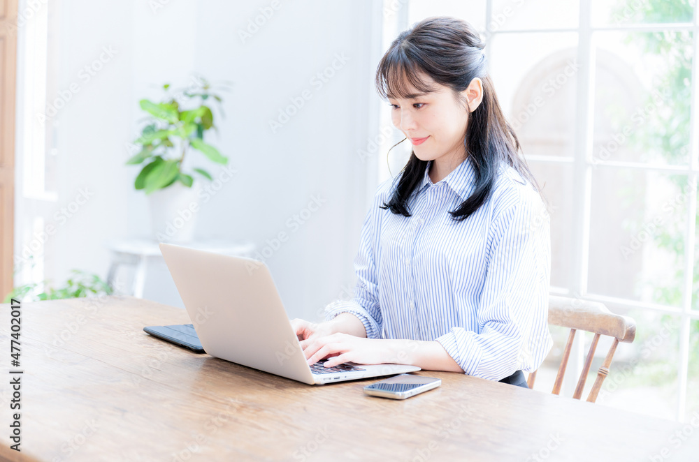 A woman working on a computer in a clean room, from the side. Copying space available. A woman working on a computer in a clean room, from the side. Copying space available.