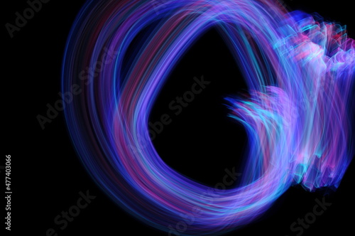 Light painting photography. Purple and blue abstract swirling texture against a black background.