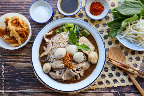 Thai style noodle soup served with vegetable flat lay on wood table - Famous street food, Thai boat noodle soup