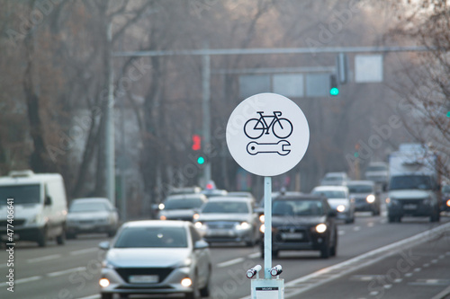 Bicycle repair round white sign on a bike lane. Bike self repair station