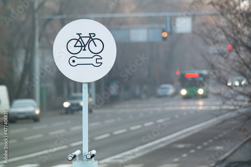 Bicycle repair round white sign on a bike lane. Bike self repair station