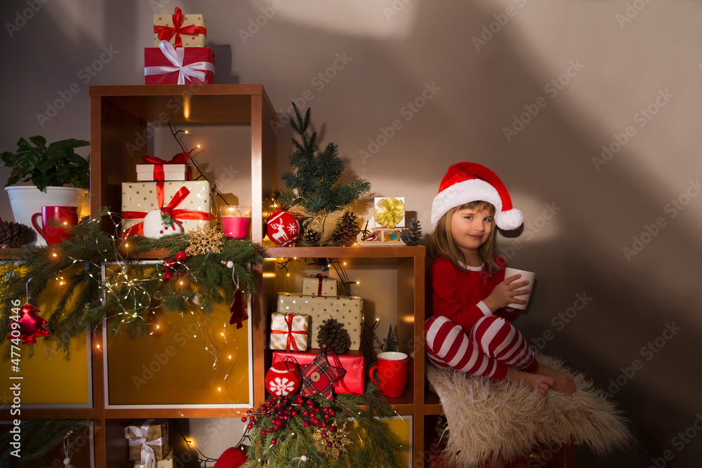 Happy New Year concept. Loving family at home on Christmas Day. advent calendar. Happy child drinks cocoa sitting on a dresser with gifts and Christmas decor