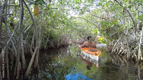 Young woman kayaking in mangrove tunnel in Nine Mile Pond in Everglades National Park, Florida on calm sunny winter afternoon 4K.