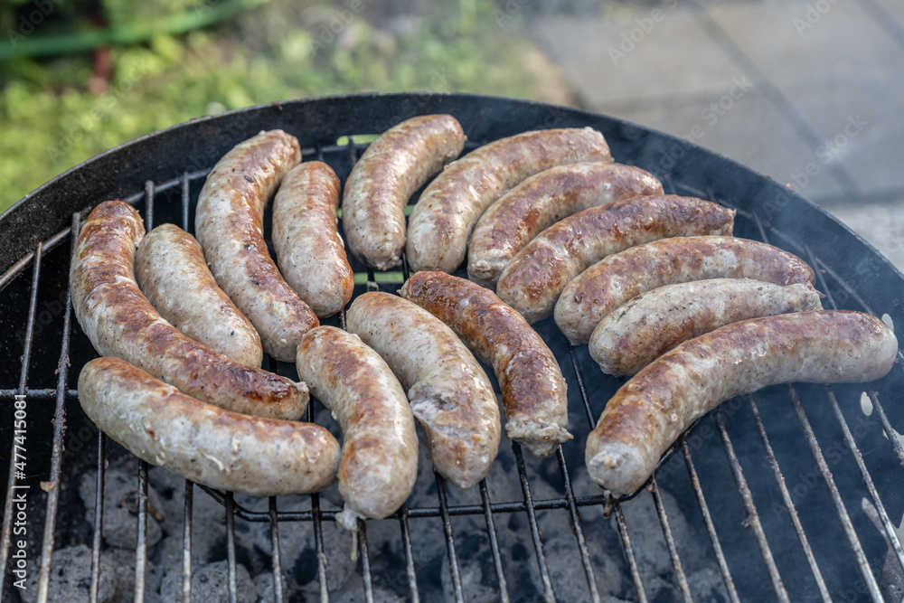 Barbecue grill bbq on coal charcoal grill with raw bratwurst sausages meat delicious summer meal
