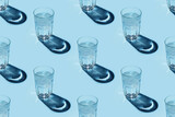 Seamless repetitive pattern with transparent glasses of water with ice cubes on blue background.