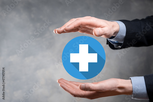 Businessman hold plus icon, man hold in hand offer positive thing such as profit, benefits, development, CSR represented by plus sign.The hand shows the plus sign.flat icons with long shadows