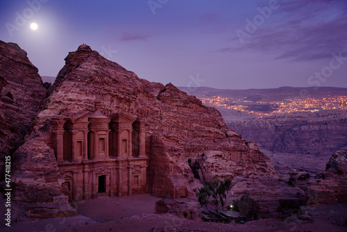 Stone Monastery in rock, Petra in Jordan. Red rock landcape. Petra historical sight - Ad Deir Monastery with full moon during the night. Evening light in nature. Travel in Jordan, Arabia in Asia. photo